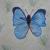 Blauer Schmetterling vor Wiese von